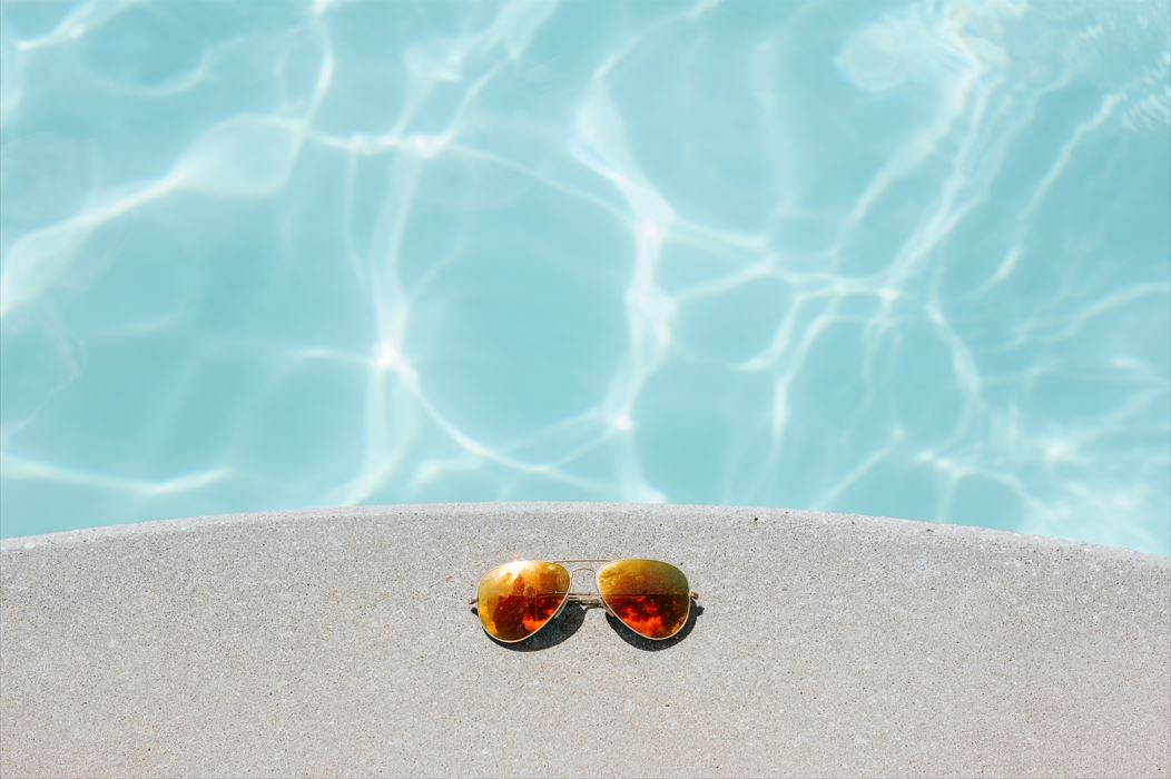 sun glasses at the edge of a pool